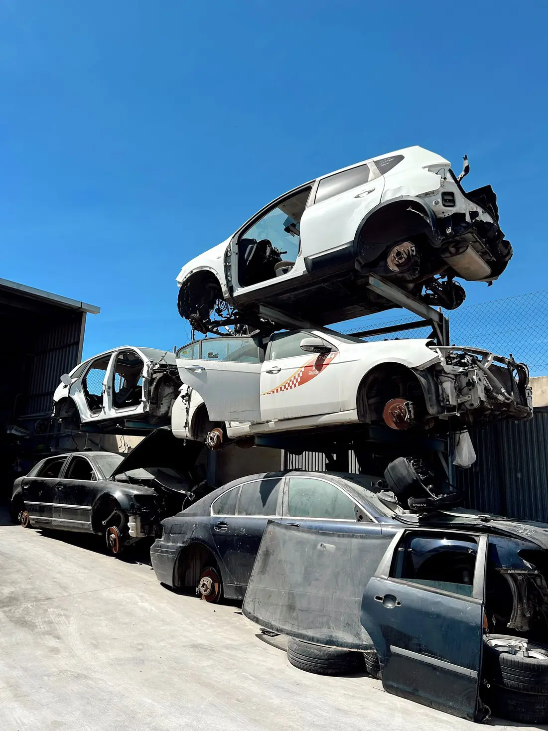 Coches desmontados apilados en la campa del desguace